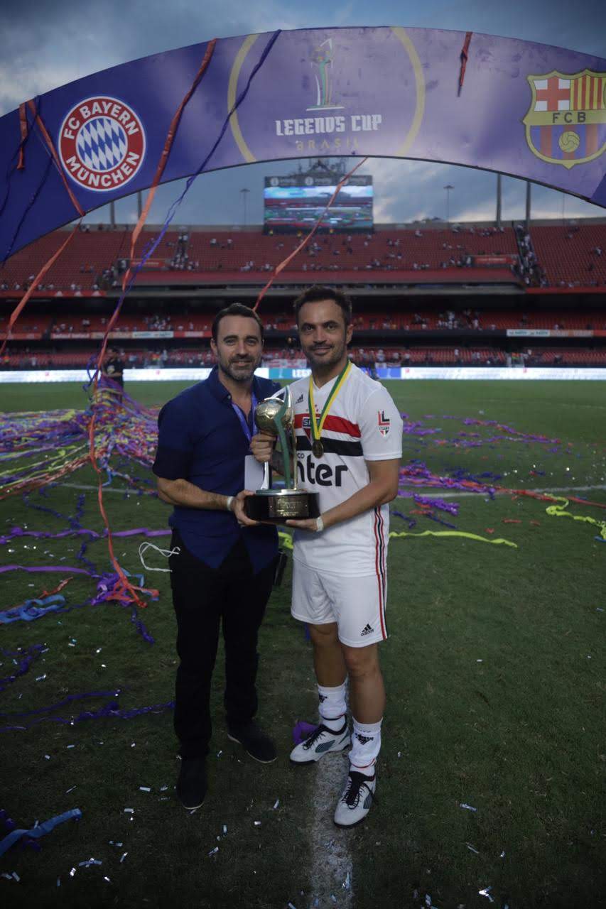 Dos personas con el trofeo de Legends Cup Brazil en la cancha del Morumbí